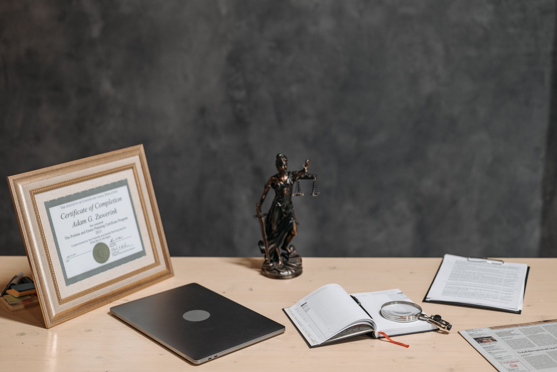 A framed diploma and documents on a desk